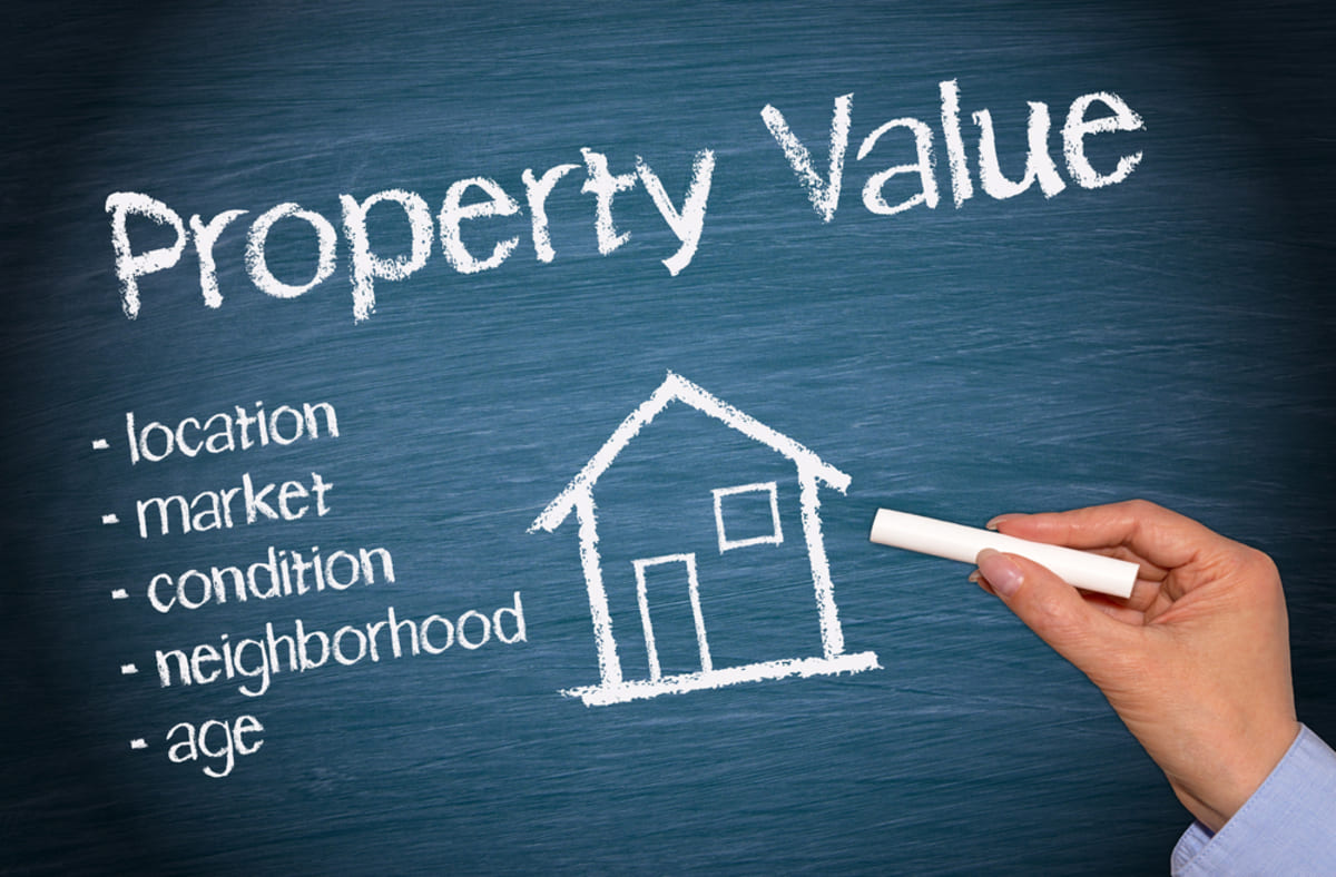 A drawing of a house and the word property value influencing factors, rental properties valuation concept