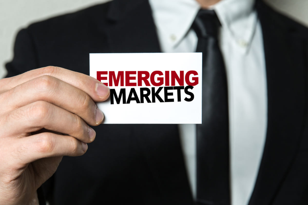 A man holding a card that says emerging markets