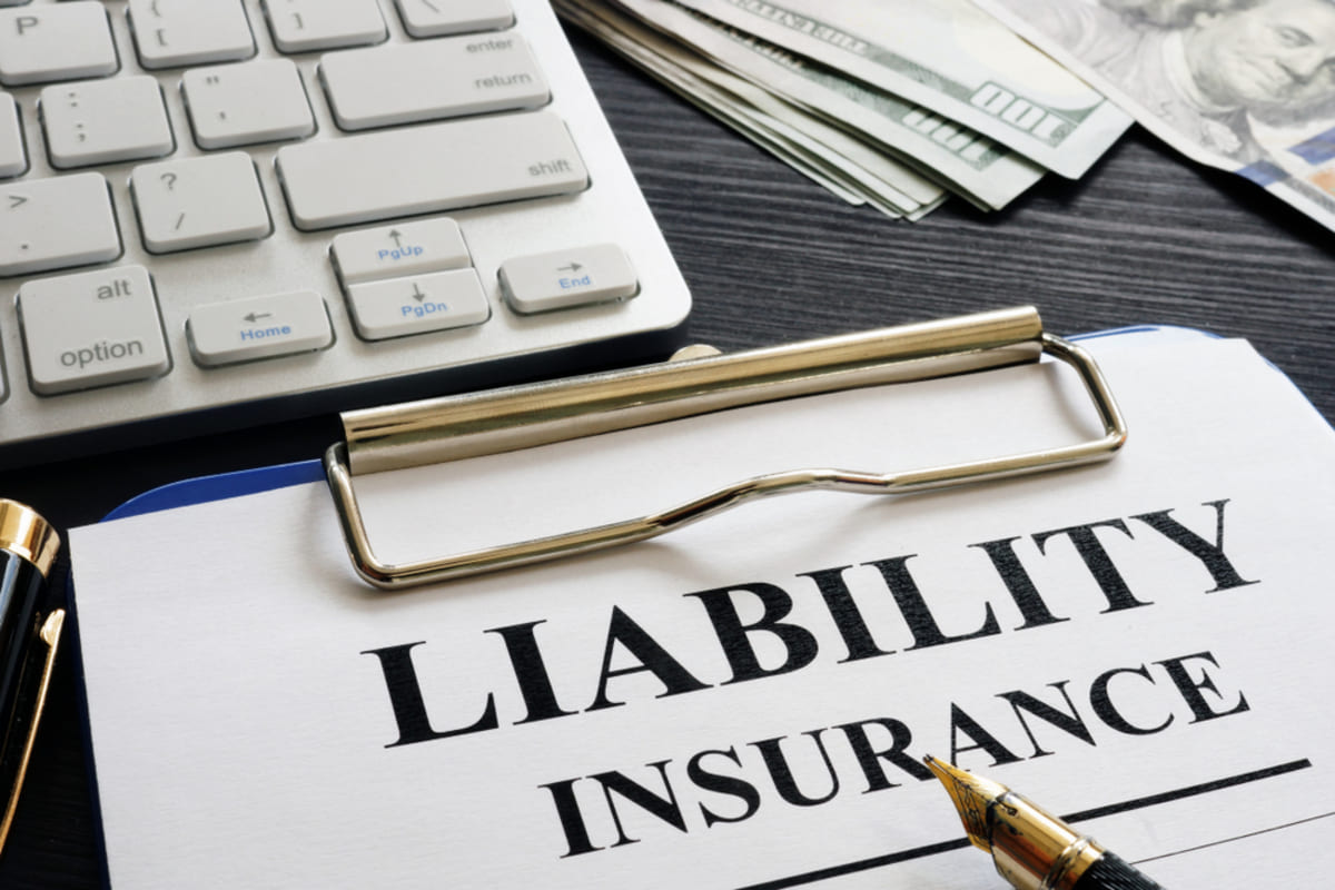 A person holding a form that says liability insurance - rental property insurance concept