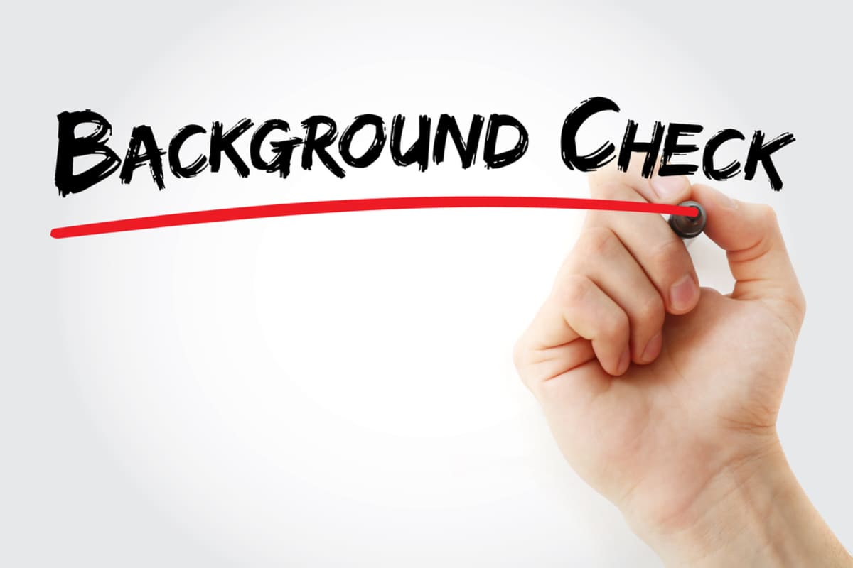 A person writing and underlining background check