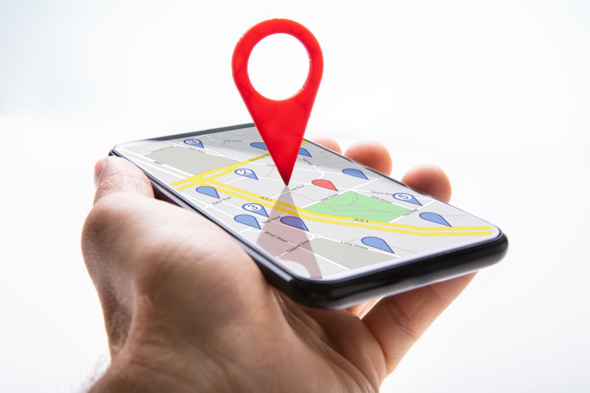 A pin sticking up out of a phone showing a location on a map
