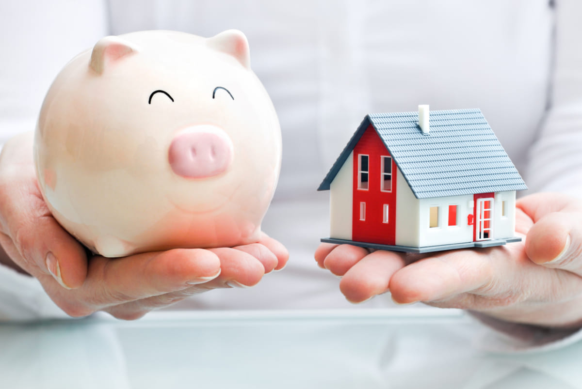 A woman holding a piggy bank and a house, effective property management concept