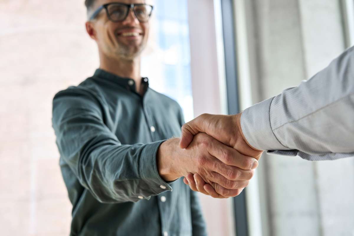 Men shaking hands as a property management services partnership with an investor