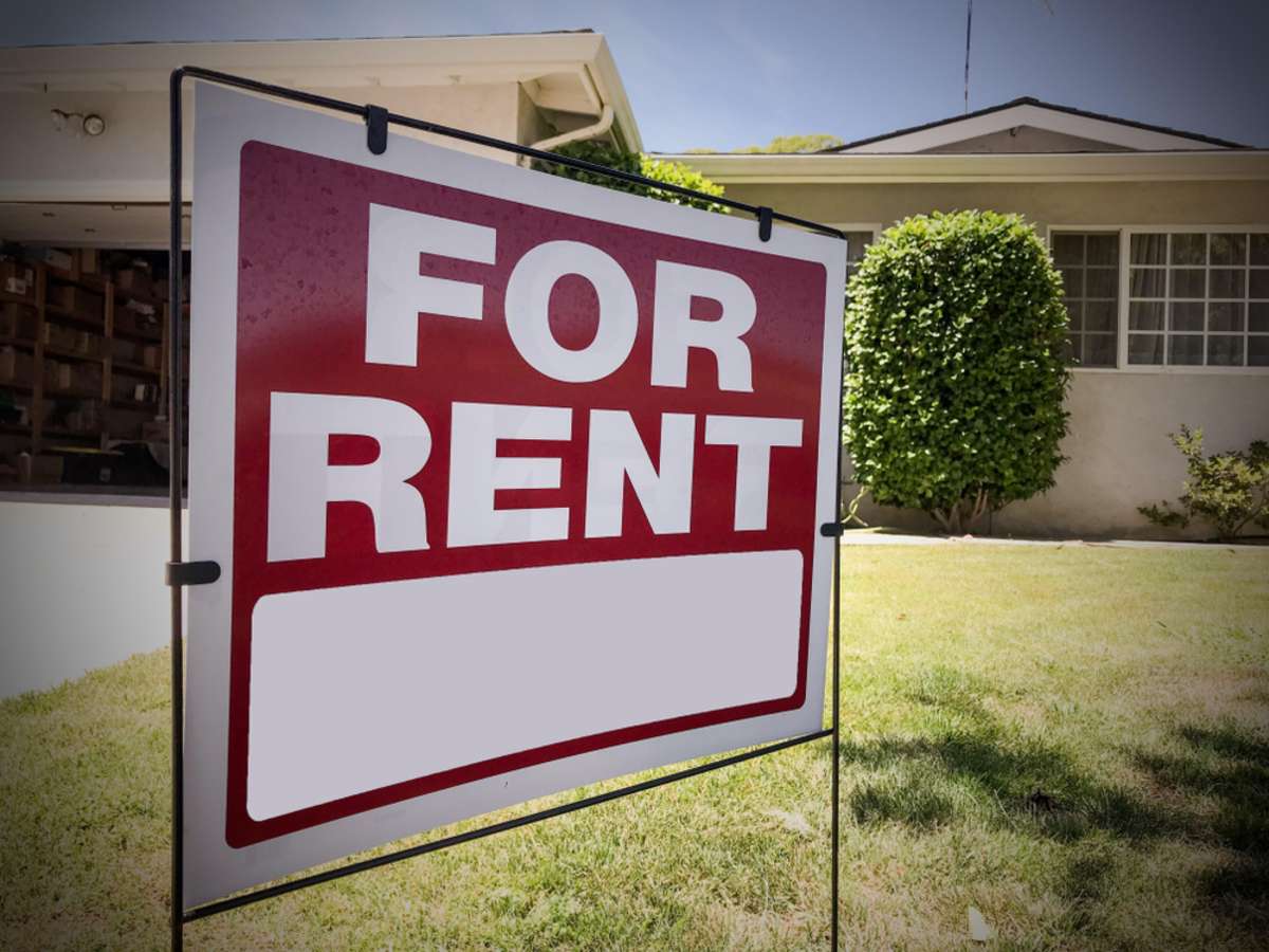 A For Rent sign in front of a home, rental property management concept