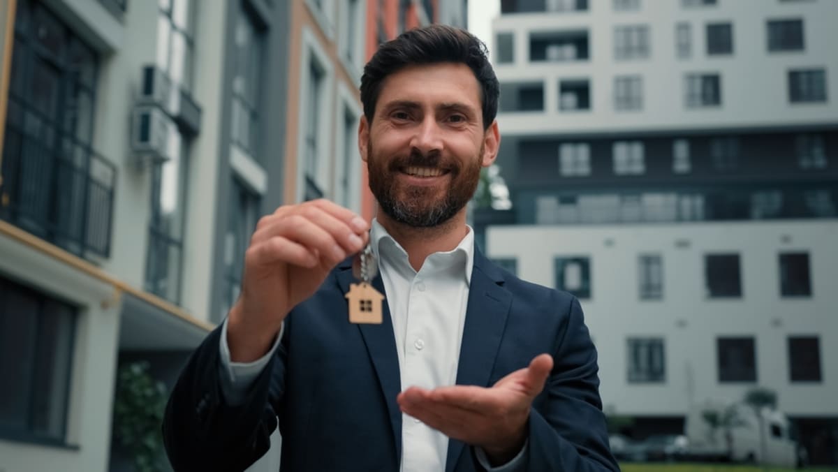  A man holding a key with a house on it