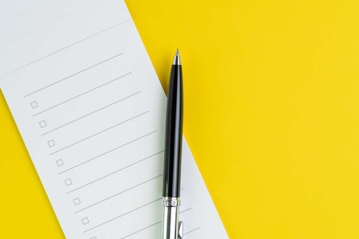Blank checklist with a pen on a yellow background, Indianapolis property management companies concept