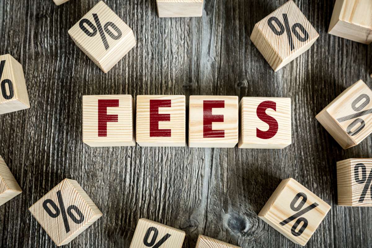 Fees spelled in wooden blocks are a reminder to review the property management services description and fees